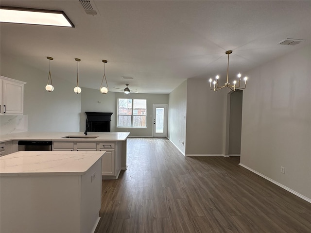 kitchen featuring dishwasher, open floor plan, a peninsula, white cabinetry, and a sink