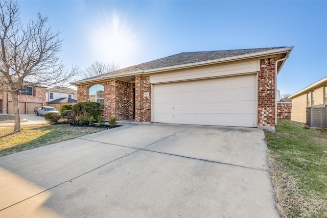 ranch-style house with driveway, brick siding, central AC, and an attached garage