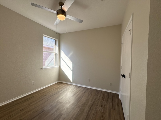 unfurnished bedroom with dark wood-style floors, ceiling fan, and baseboards