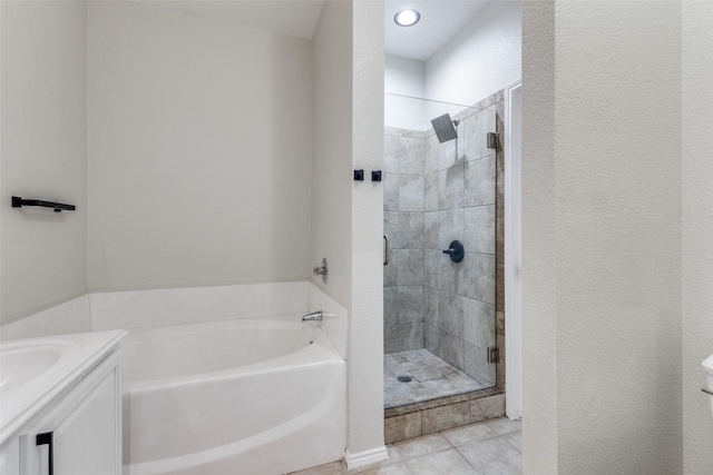 bathroom featuring a stall shower, vanity, a garden tub, and tile patterned floors