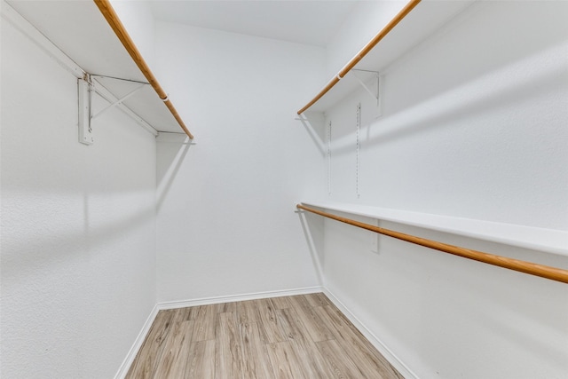 spacious closet with attic access and light wood-style floors