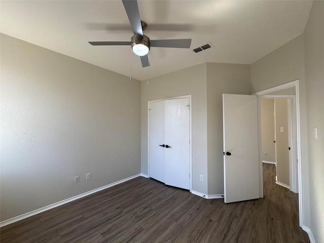 unfurnished bedroom featuring a ceiling fan, dark wood-style flooring, visible vents, and baseboards