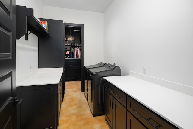 laundry area featuring separate washer and dryer and cabinet space