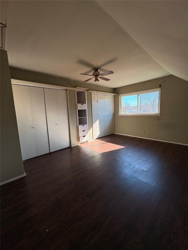 unfurnished bedroom featuring lofted ceiling, dark hardwood / wood-style floors, and ceiling fan