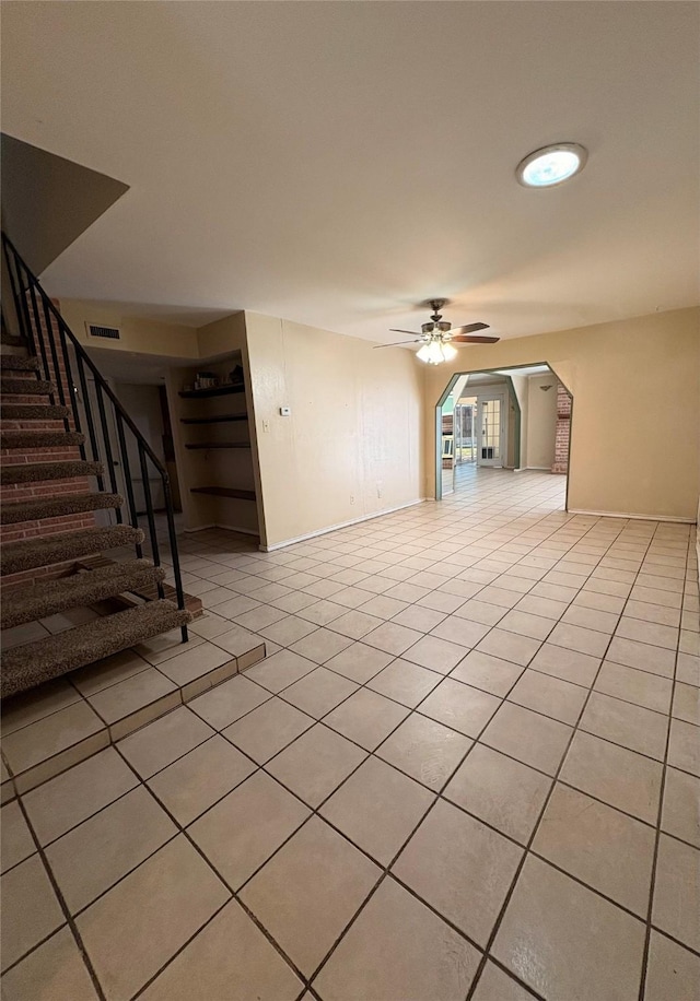 unfurnished living room with light tile patterned floors and ceiling fan