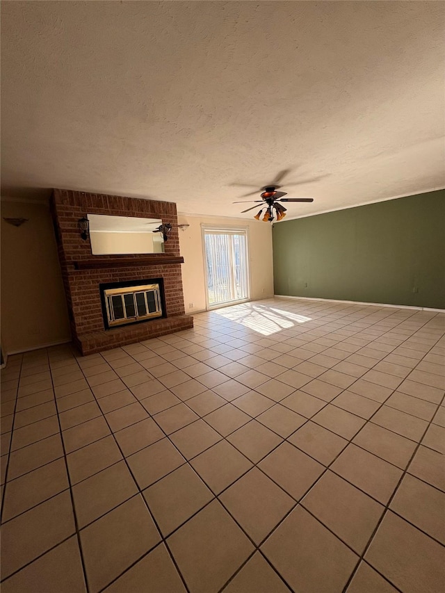 unfurnished living room with ceiling fan, a brick fireplace, light tile patterned floors, and a textured ceiling