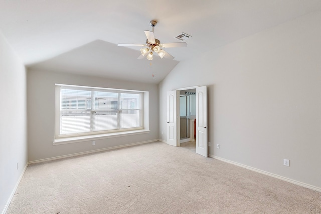 carpeted spare room with ceiling fan and vaulted ceiling