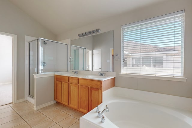 bathroom featuring tile patterned floors, vanity, lofted ceiling, and a healthy amount of sunlight