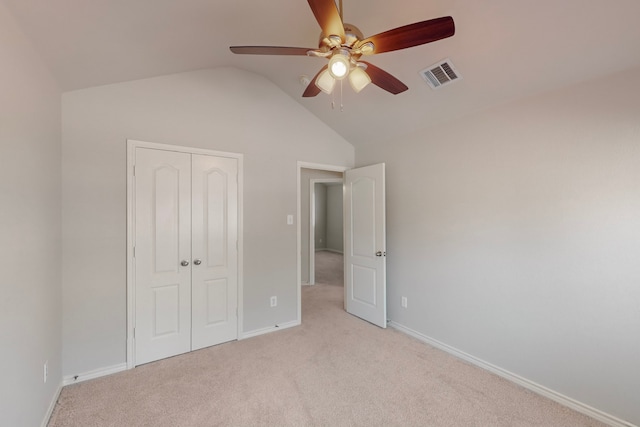 unfurnished bedroom with ceiling fan, light carpet, a closet, and lofted ceiling