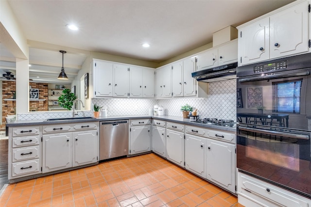 kitchen with appliances with stainless steel finishes, pendant lighting, sink, white cabinets, and backsplash