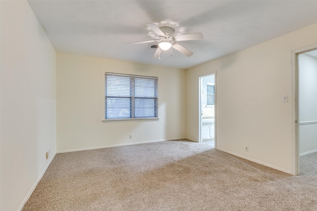 spare room featuring light colored carpet and ceiling fan