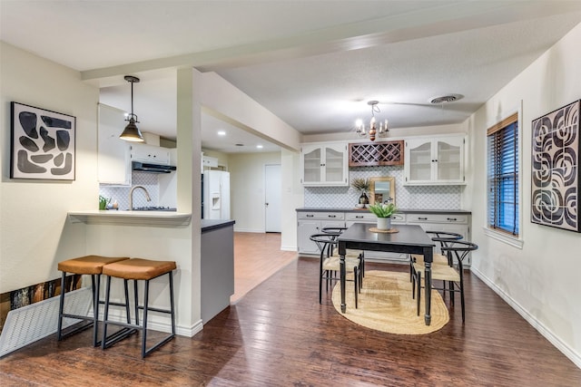 kitchen with white cabinetry, sink, dark hardwood / wood-style flooring, decorative backsplash, and white fridge with ice dispenser