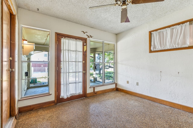 empty room with a textured ceiling, carpet flooring, and ceiling fan