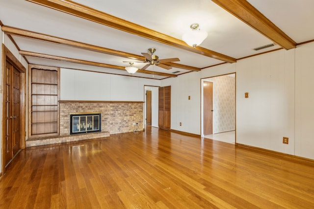 unfurnished living room with a fireplace, light hardwood / wood-style flooring, beamed ceiling, and ceiling fan