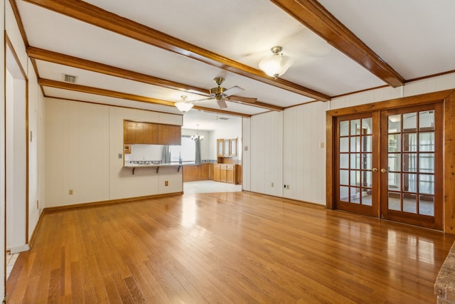 unfurnished living room featuring light hardwood / wood-style floors, beam ceiling, french doors, and ceiling fan with notable chandelier