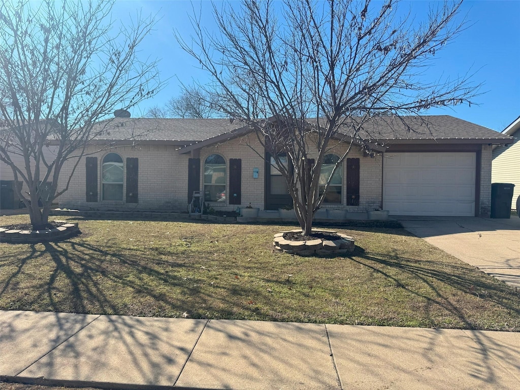 ranch-style house featuring a garage and a front lawn