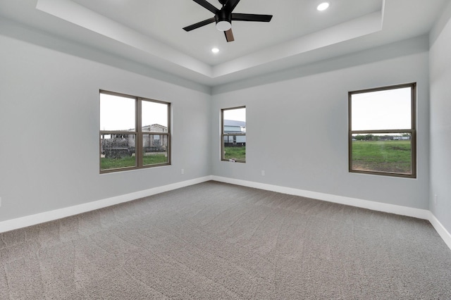 spare room featuring baseboards, recessed lighting, a ceiling fan, and a tray ceiling