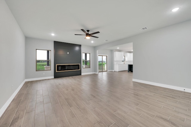 unfurnished living room with recessed lighting, light wood-style floors, ceiling fan, baseboards, and visible vents