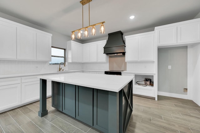 kitchen featuring backsplash, light countertops, premium range hood, white cabinets, and electric range