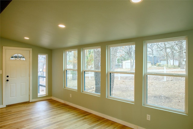 entrance foyer with vaulted ceiling and light hardwood / wood-style floors