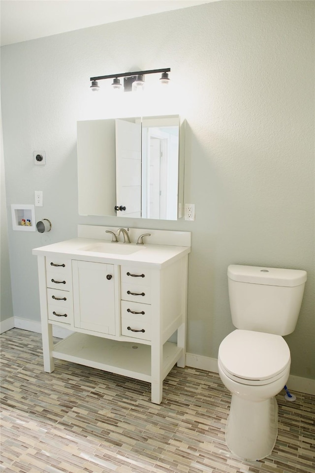 bathroom with vanity, toilet, and hardwood / wood-style floors