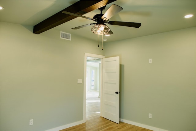 spare room featuring beam ceiling and light wood-type flooring