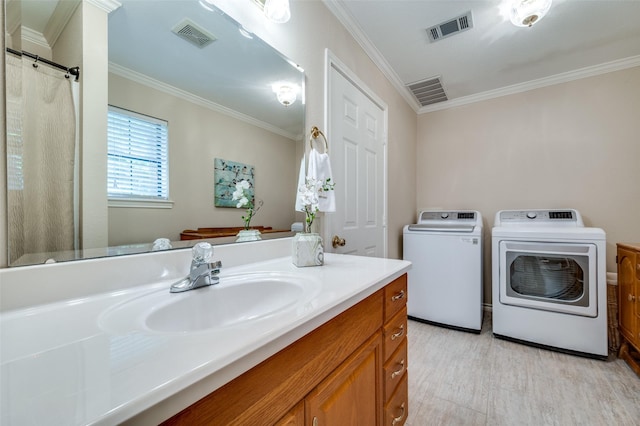 bathroom with vanity, wood-type flooring, ornamental molding, and independent washer and dryer