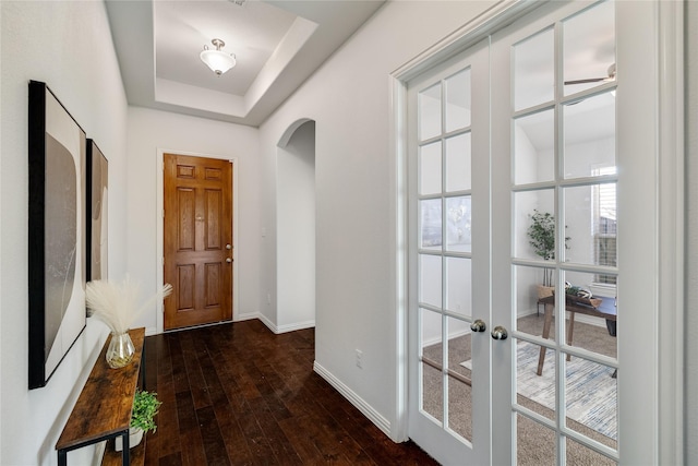 doorway featuring french doors, a tray ceiling, and dark hardwood / wood-style flooring