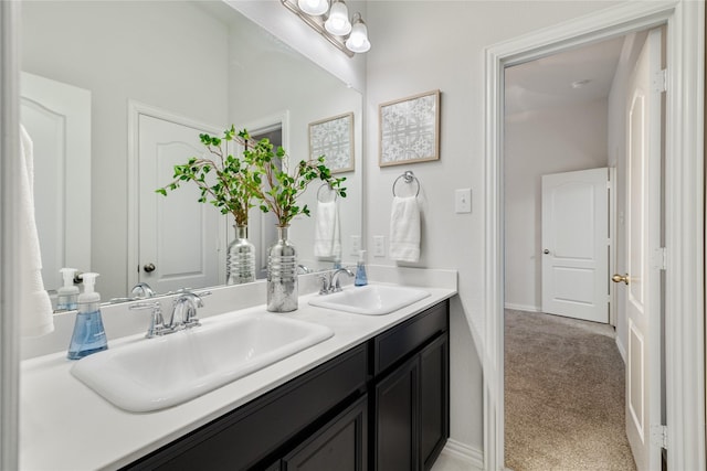 full bathroom featuring double vanity, baseboards, and a sink