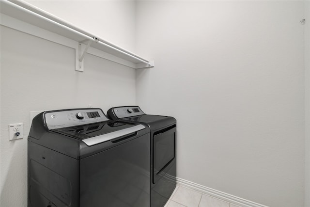 laundry room featuring light tile patterned floors and washing machine and dryer