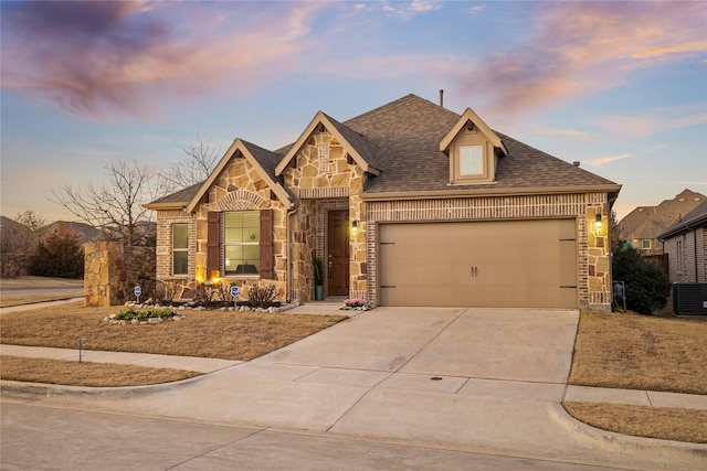 view of front of property featuring cooling unit and a garage