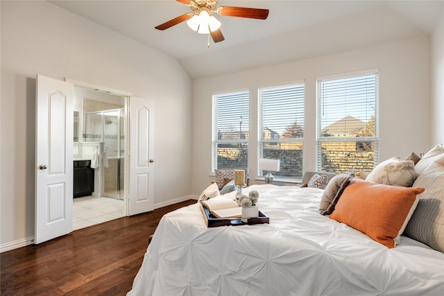 bedroom featuring lofted ceiling, connected bathroom, a fireplace, wood finished floors, and baseboards