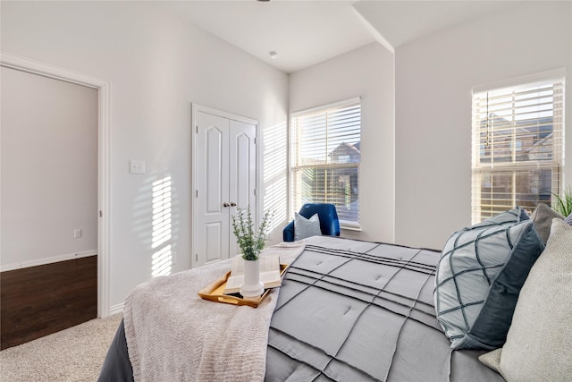 carpeted bedroom with a closet and baseboards