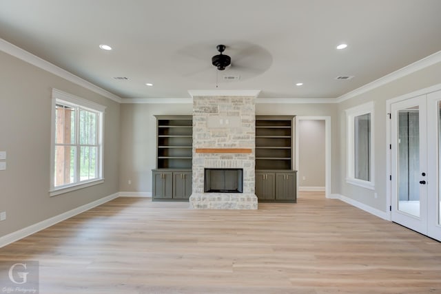 unfurnished living room with french doors, a stone fireplace, ornamental molding, and light hardwood / wood-style floors