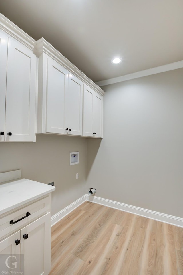 laundry area featuring cabinets, light hardwood / wood-style flooring, and hookup for a washing machine