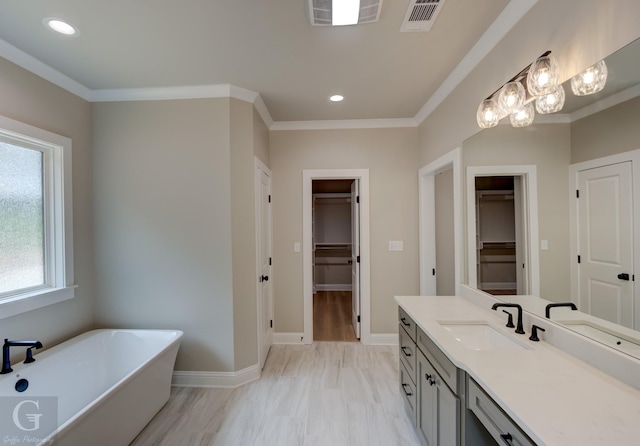 bathroom with vanity, a tub, and crown molding