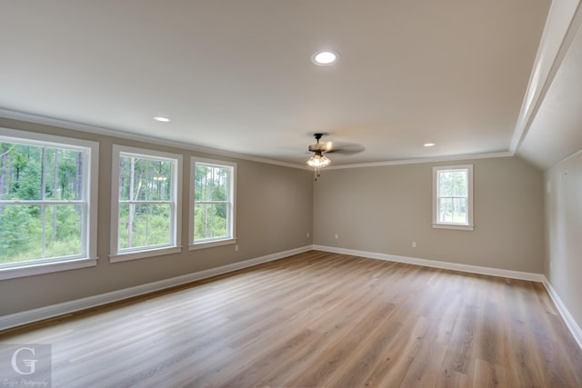 empty room featuring ceiling fan, light hardwood / wood-style flooring, crown molding, and vaulted ceiling