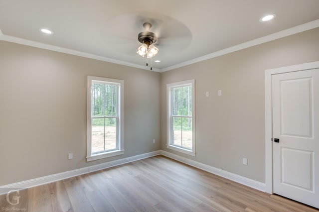 spare room featuring ceiling fan, a healthy amount of sunlight, crown molding, and light hardwood / wood-style floors