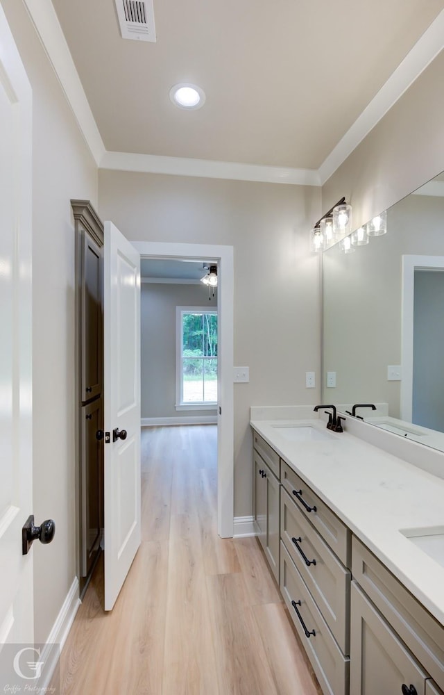 bathroom featuring hardwood / wood-style floors, vanity, and ornamental molding