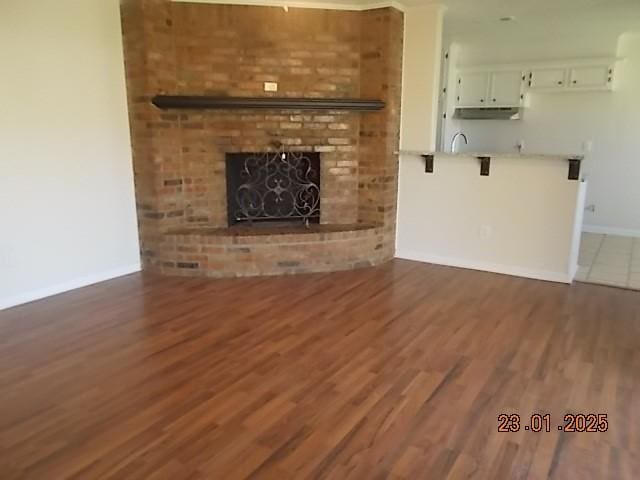 unfurnished living room with dark hardwood / wood-style flooring and a fireplace