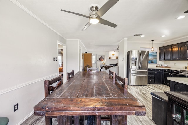 dining area with crown molding, light hardwood / wood-style flooring, and ceiling fan