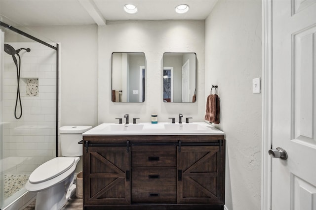 bathroom featuring vanity, toilet, and a shower with door