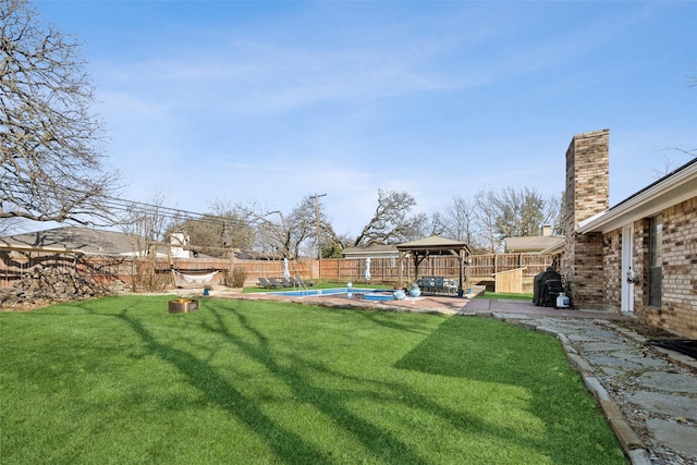 view of yard featuring a fenced in pool and a gazebo