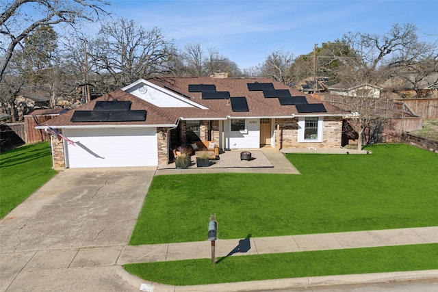 view of front of house featuring a garage, a front lawn, and solar panels