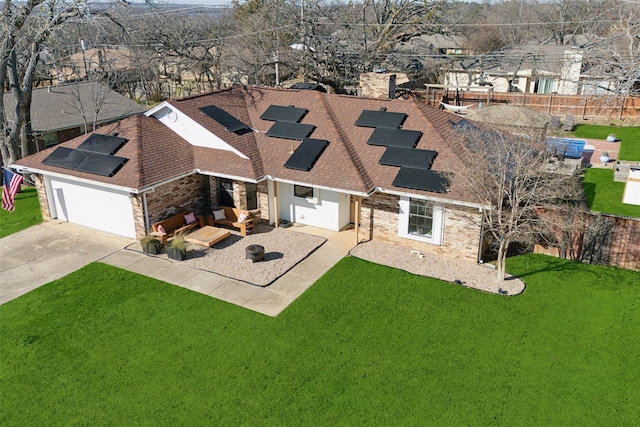 view of front facade with a patio area, a garage, a front lawn, and solar panels