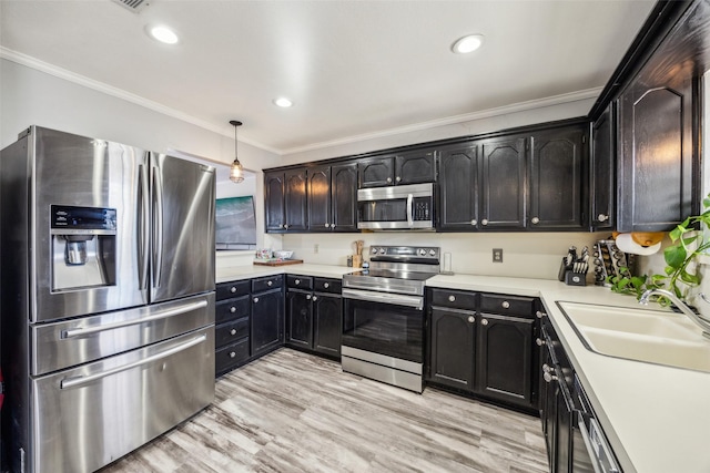 kitchen with sink, crown molding, decorative light fixtures, appliances with stainless steel finishes, and light hardwood / wood-style floors