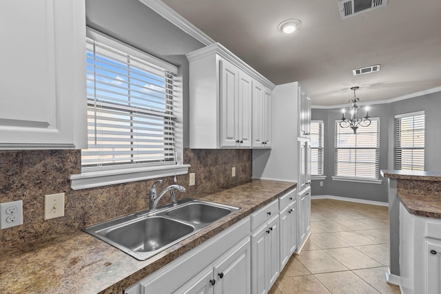 kitchen featuring white cabinetry, sink, light tile patterned flooring, and decorative backsplash