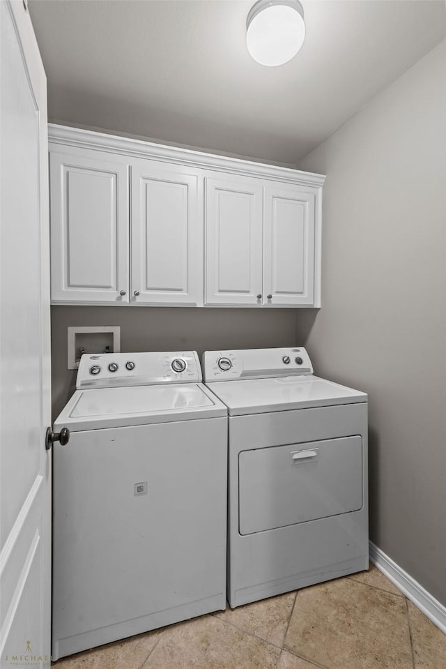 laundry room with cabinets, separate washer and dryer, and light tile patterned floors