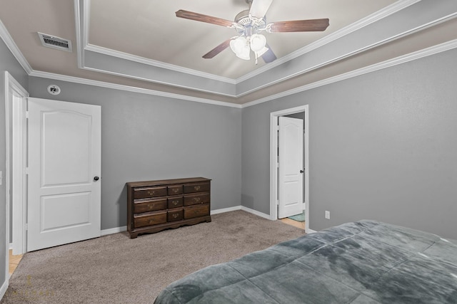 bedroom with ceiling fan, ornamental molding, a tray ceiling, and light carpet