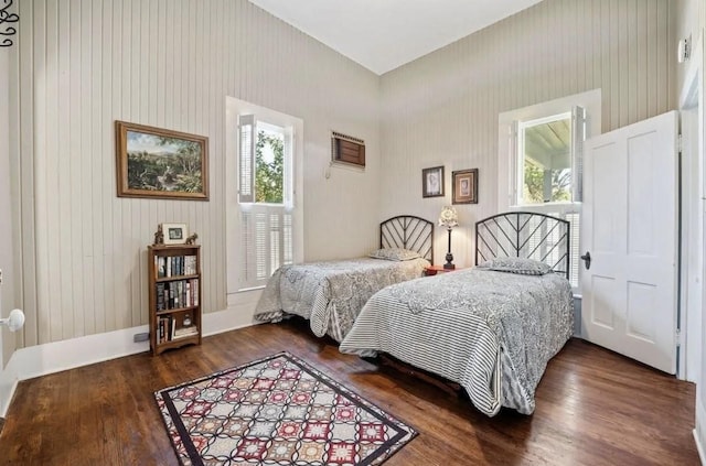 bedroom with dark hardwood / wood-style flooring and multiple windows